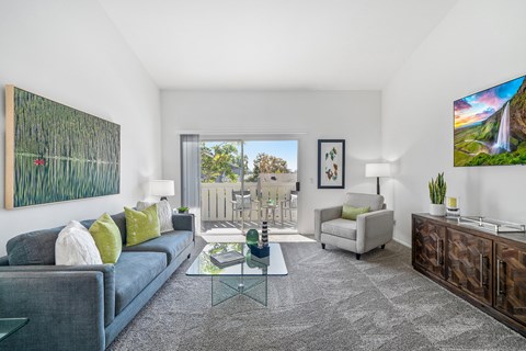 a living room with a blue couch and a glass coffee table