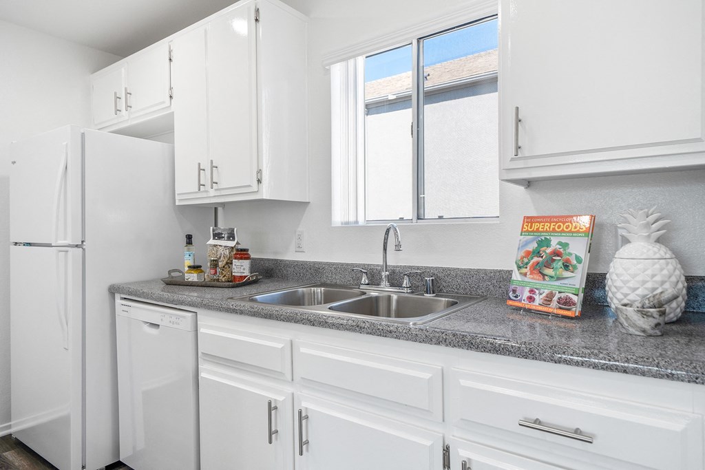 a kitchen with white cabinets and granite counter top and a sink