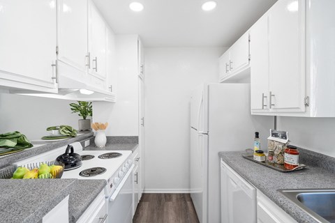 a white kitchen with white appliances and granite counter tops
