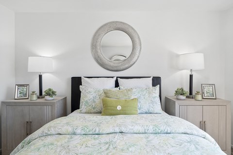 a bedroom with a bed with a green and white comforter and pillows