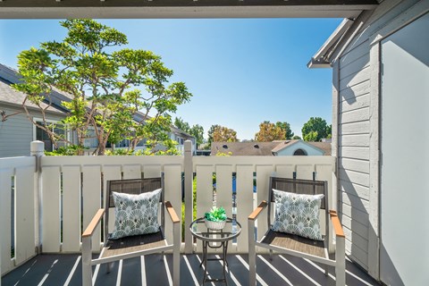 a balcony with two chairs and a table