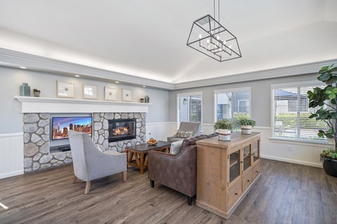 a living room with a stone fireplace and a wood floor