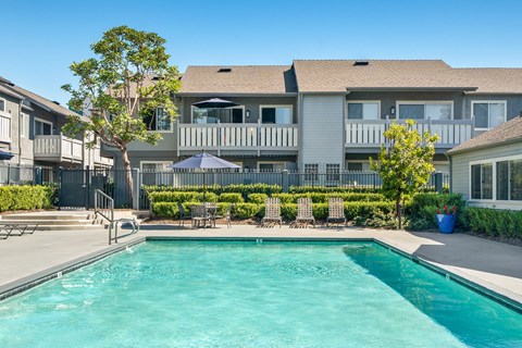 a swimming pool with a house in the background