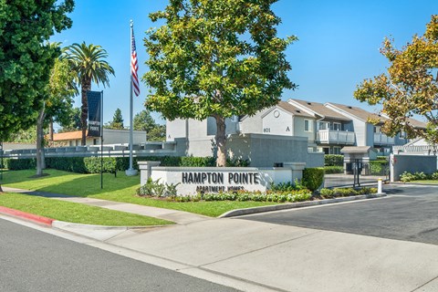 a sign for the pointe neighborhood with houses in the background