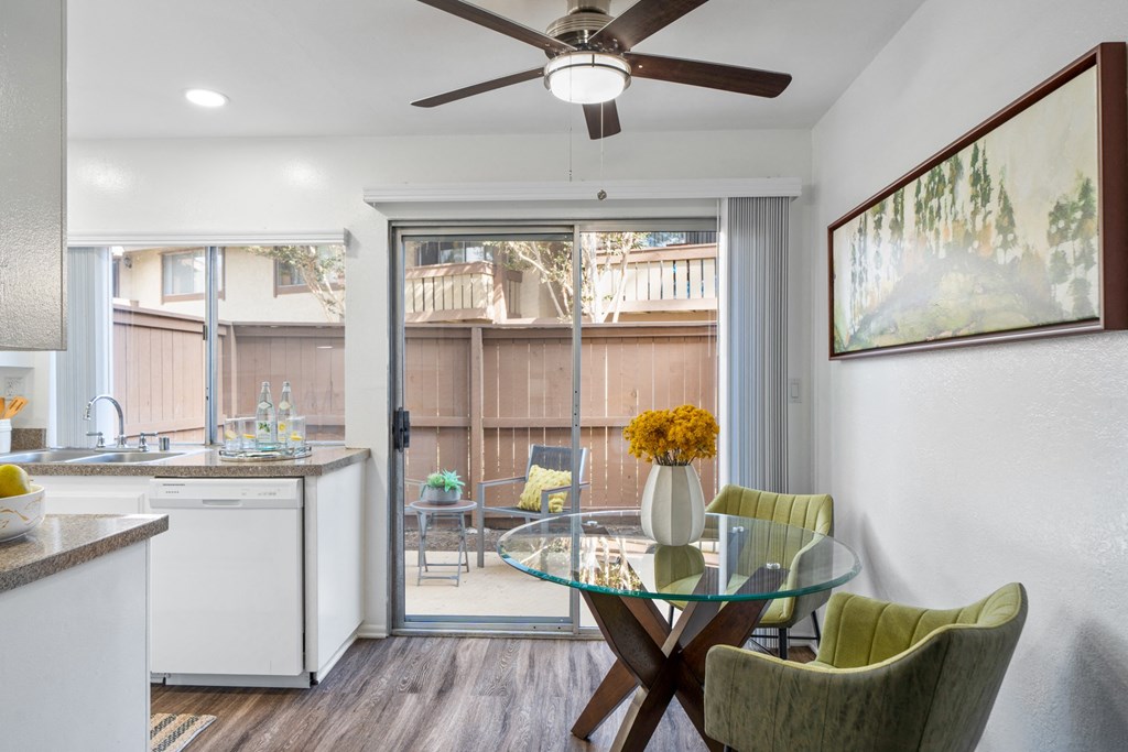 a kitchen and dining area with a glass table and chairs and a sliding glass door