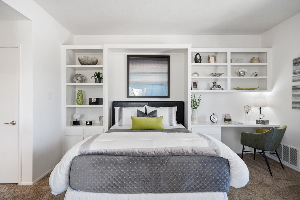 a bedroom with a bed and a desk with a chair