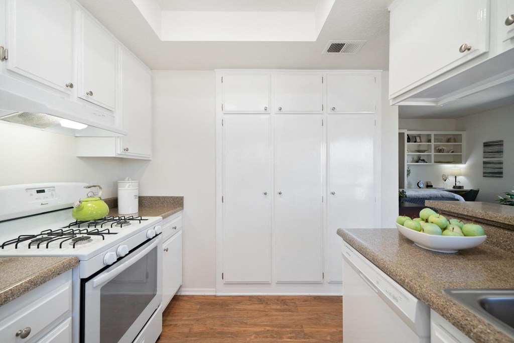 a kitchen with white cabinetry and a white stove top oven