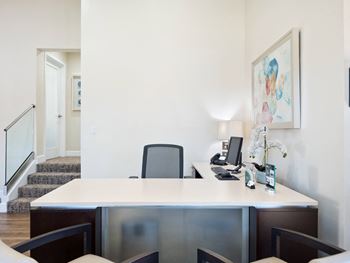 a desk with a computer and a chair in a room