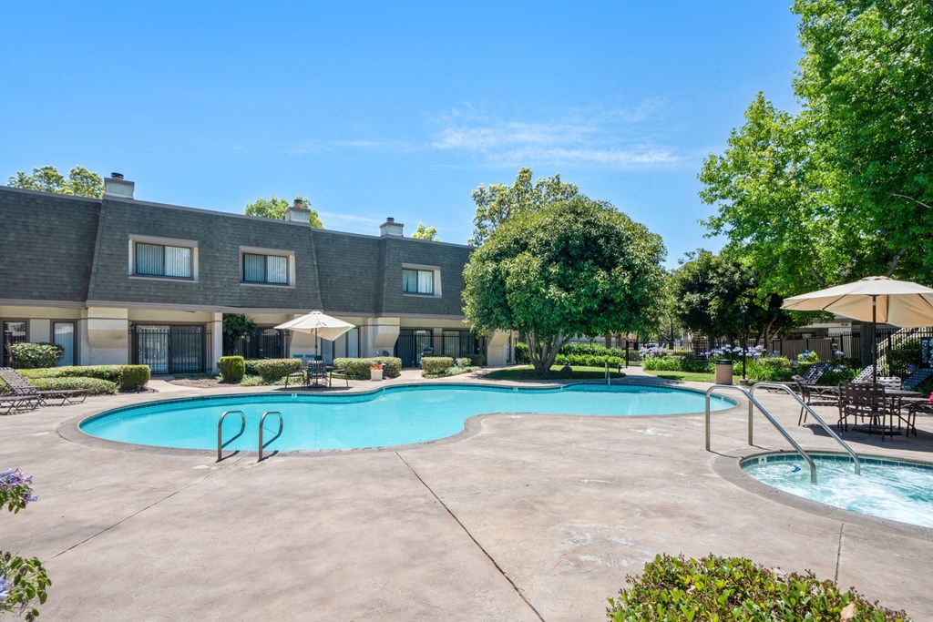 a swimming pool with umbrellas and a building in the background