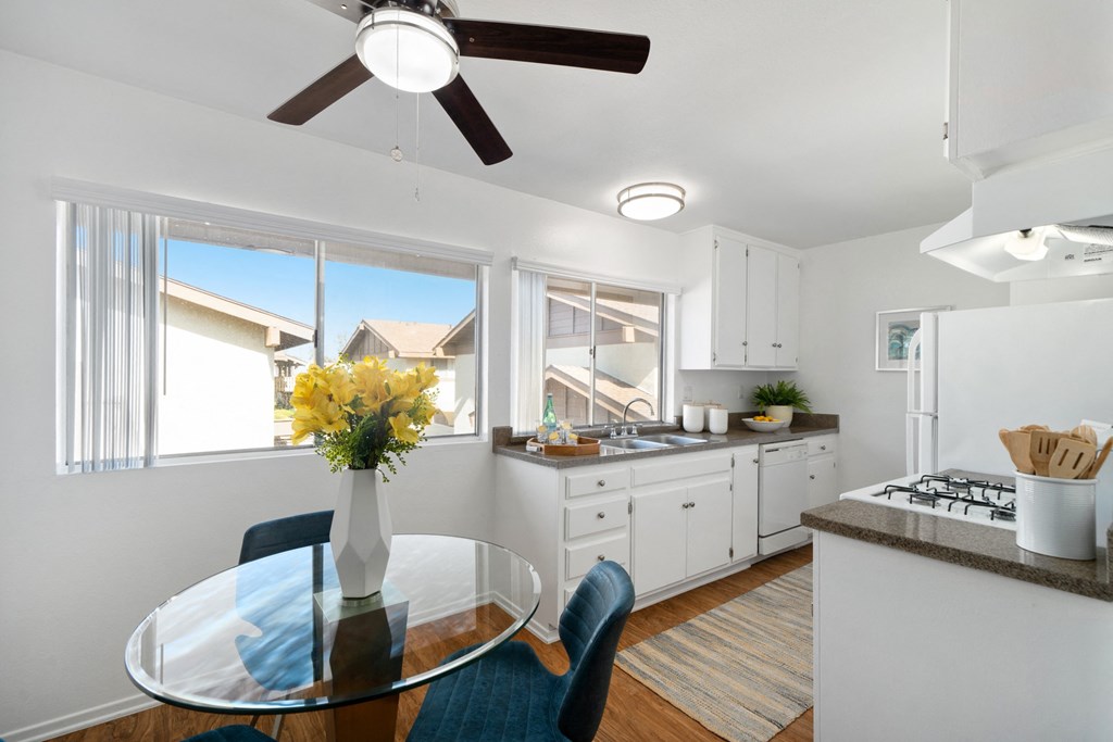 an open kitchen and dining room with a glass table and chairs