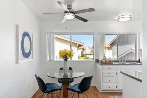 a dining room with a table and chairs and a ceiling fan