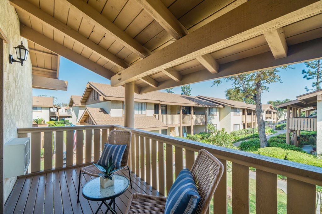 a balcony with two chairs and a table