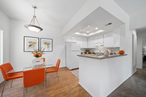 a dining room and kitchen with a table and chairs