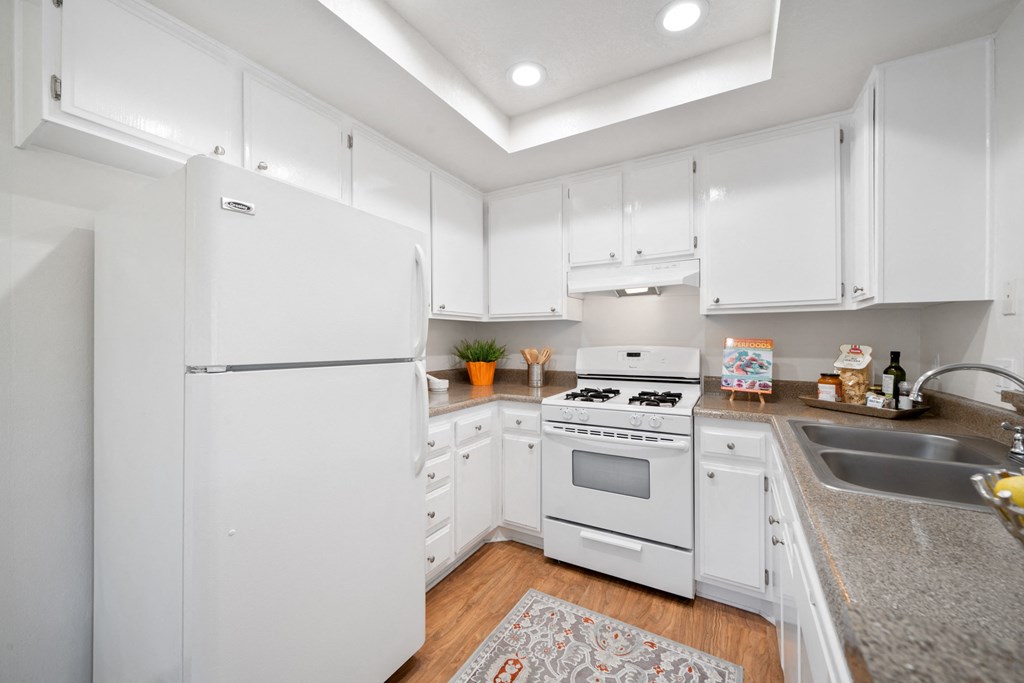 a kitchen with white cabinetry and white appliances