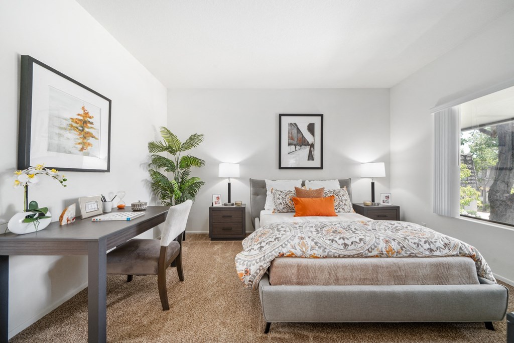 a bedroom with a large bed and a desk with a chair