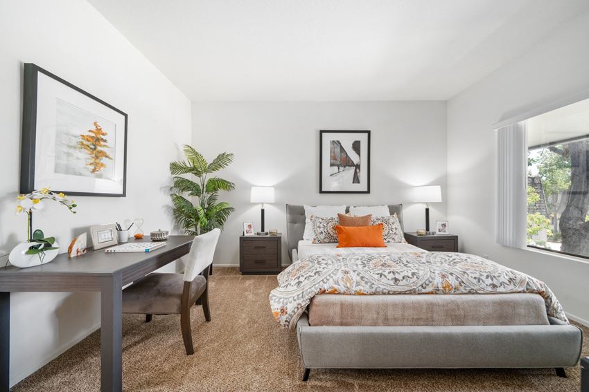 a bedroom with a large bed and a desk with a chair - Photo Gallery