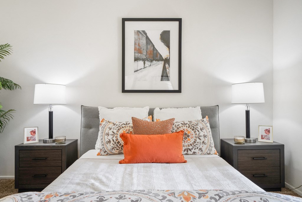 a bedroom with a bed and two night stands with lamps on them