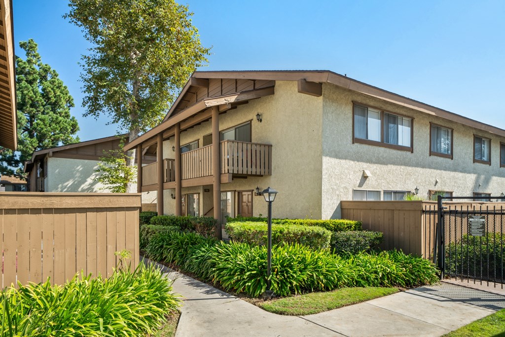 a house with a sidewalk and a fence in front of it