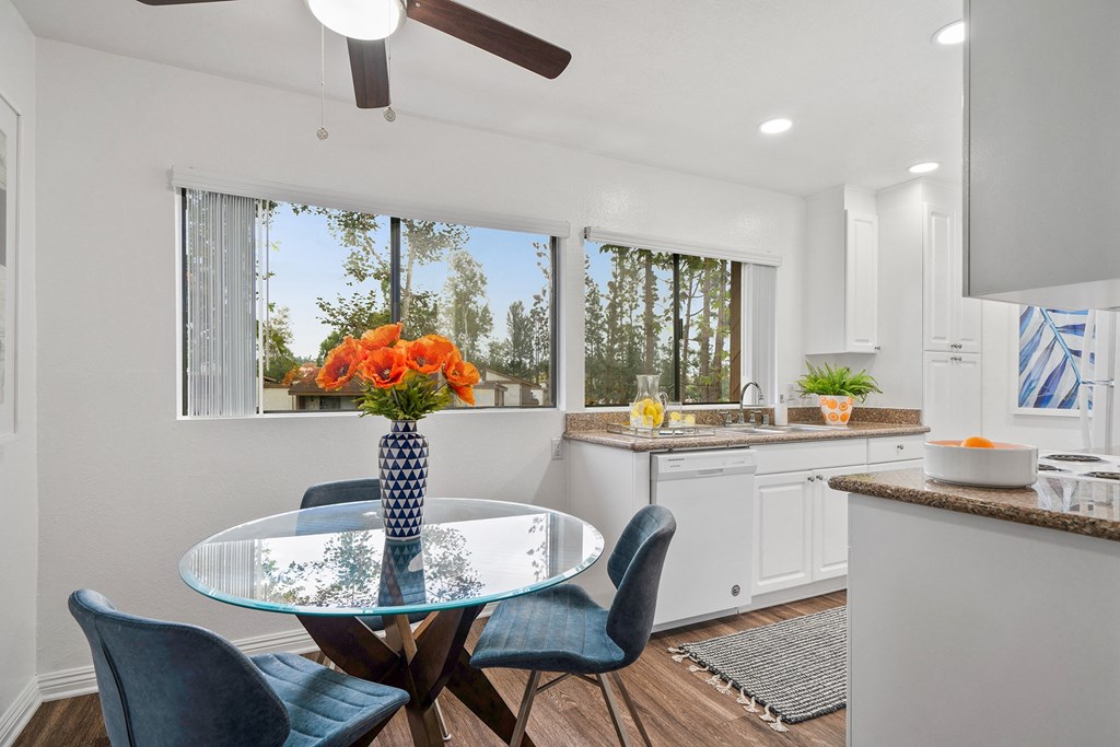 an open kitchen and dining room with a glass table and chairs