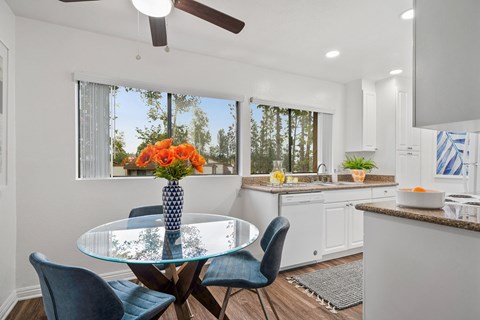 an open kitchen and dining room with a glass table and chairs