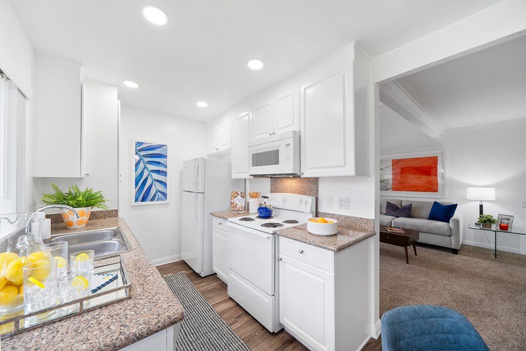 a kitchen with white cabinets and a counter top and a sink