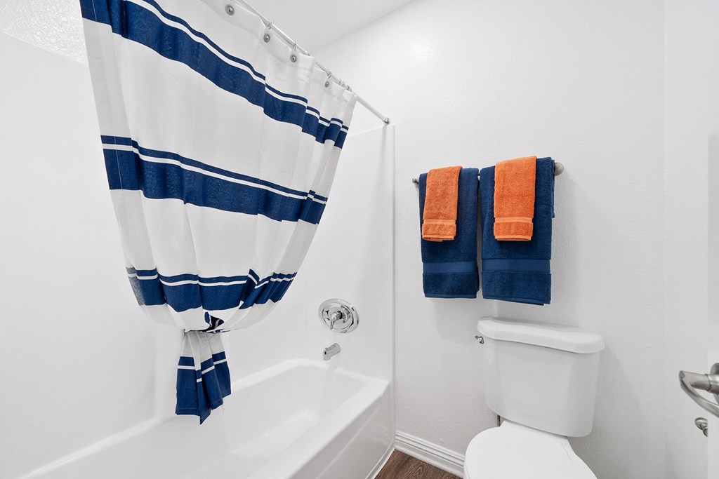 a bathroom with a shower and a toilet and two towels