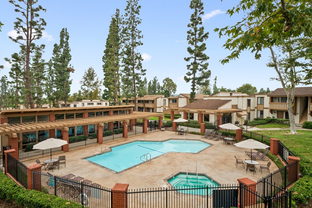 a courtyard with a pool and buildings with trees