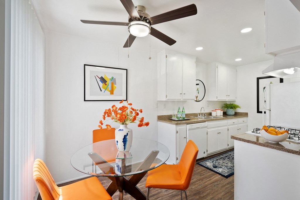 a kitchen and dining room with a glass table and chairs