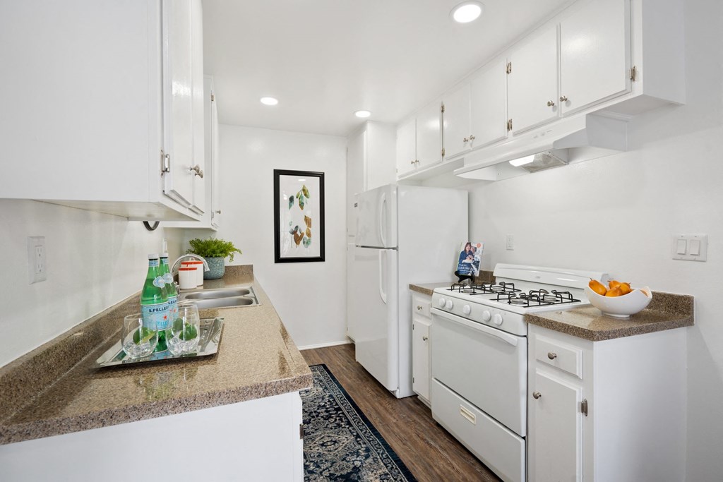 a white kitchen with white appliances and white cabinets