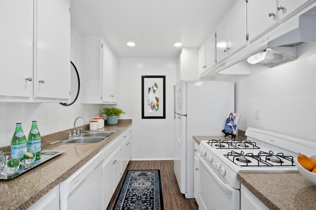 a white kitchen with white appliances and white cabinets