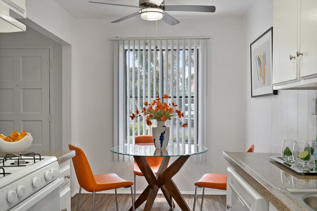 a kitchen with a table with a vase of flowers on it