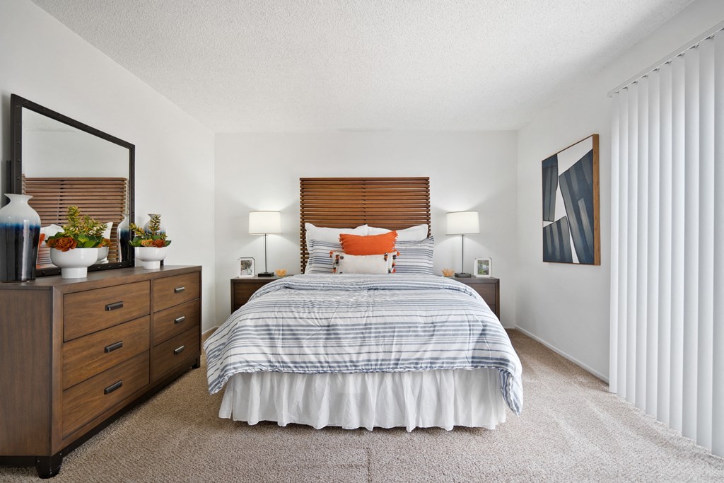 a bedroom with a bed and a dresser and a window