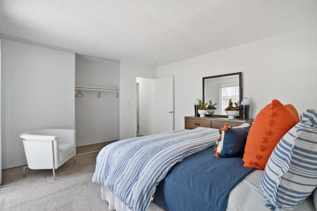 a bedroom with a bed and a chair and a closet