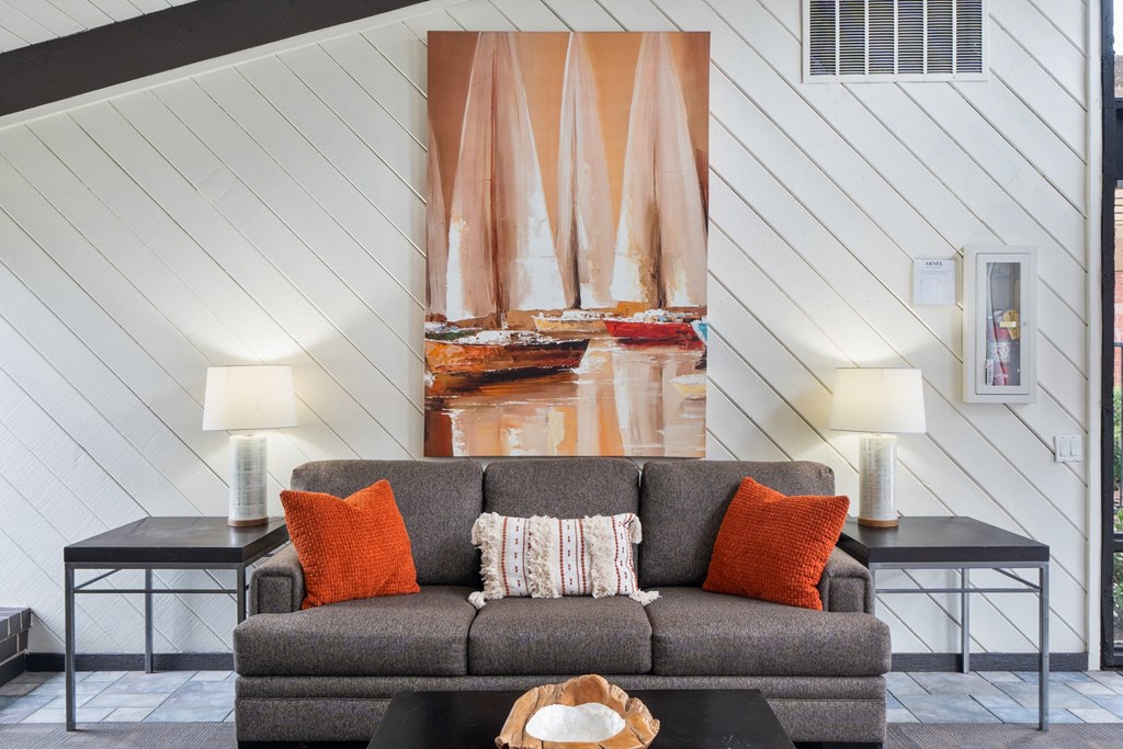 a living room with a couch and a painting on the wall