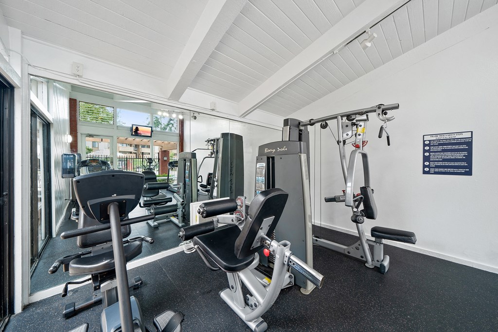 a gym with cardio equipment and weights on the floor
