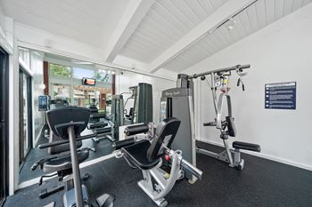 a gym with cardio equipment and weights on the floor
