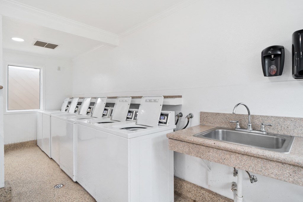 a washer and dryer in a laundry room with a sink