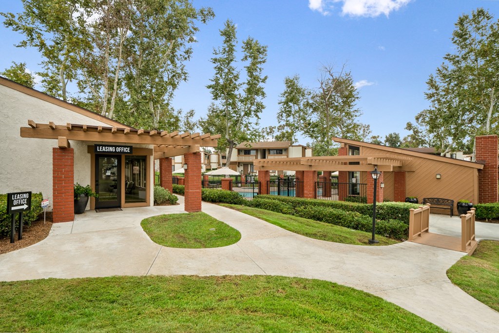 a building with a sidewalk and trees in front of it