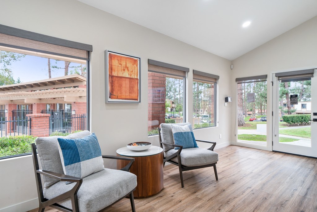 a living room with two chairs and a table and sliding glass doors