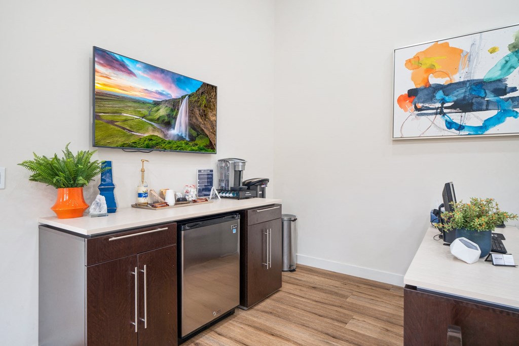 a kitchen with a counter and a refrigerator and a painting on the wall