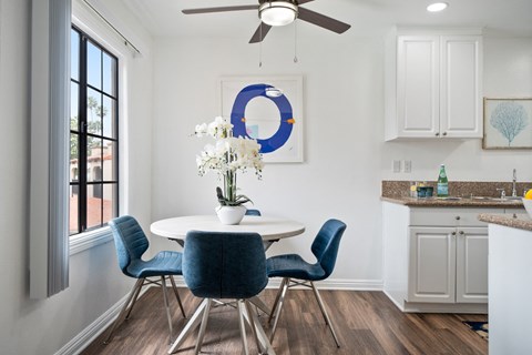 a dining area with a round table and blue chairs