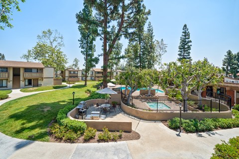 A pool surrounded by a fence and trees in a residential area.