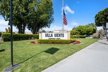a sign for villa vincento flags in front of it