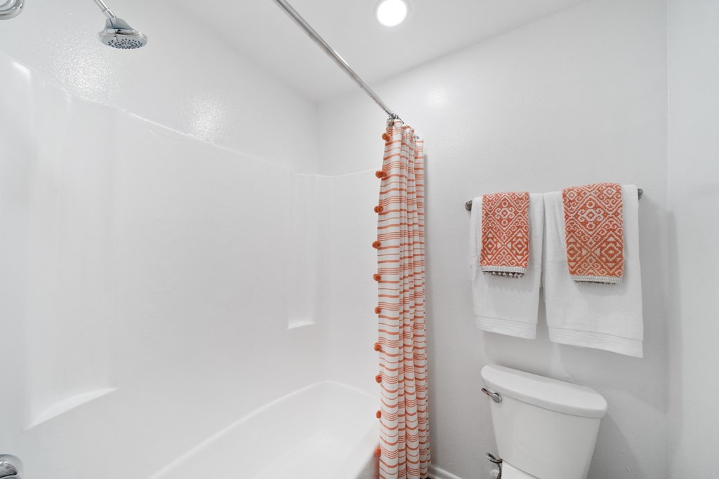 a bathroom with a shower and a toilet and a shower curtain