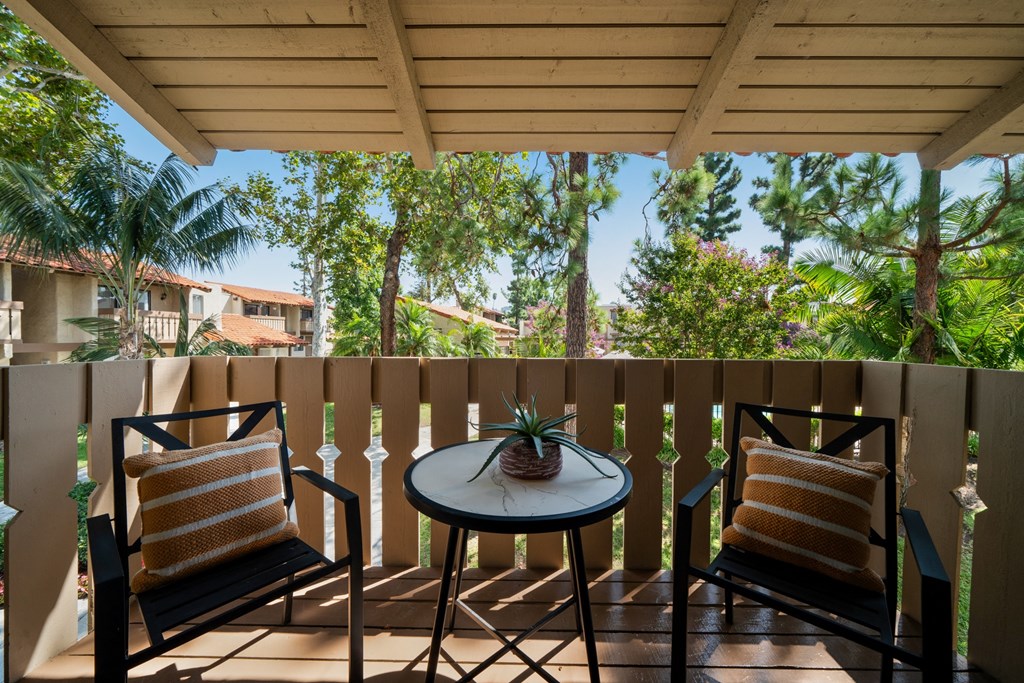 a patio with two chairs and a table on a balcony