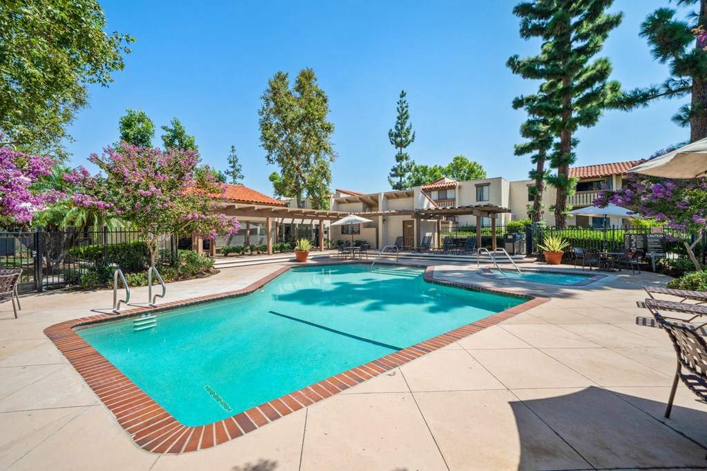 a swimming pool with trees and a building in the background