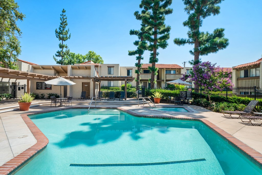 a swimming pool with trees and a building in the background