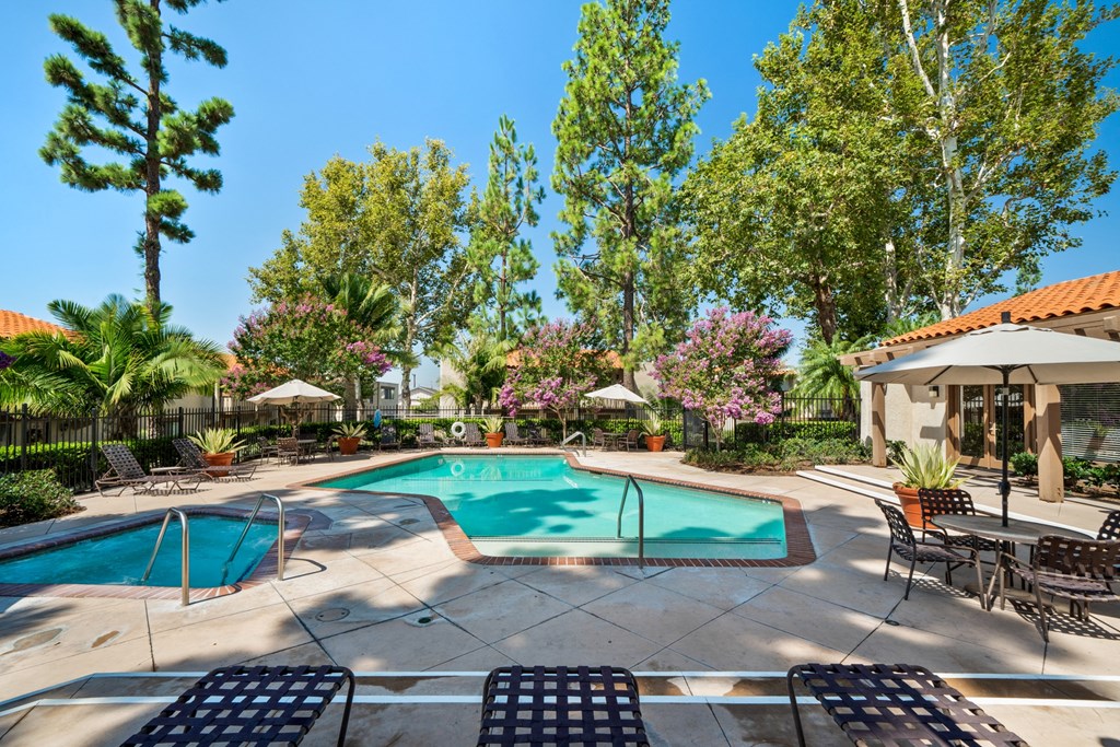 a swimming pool with chairs and umbrellas next to a resort style pool