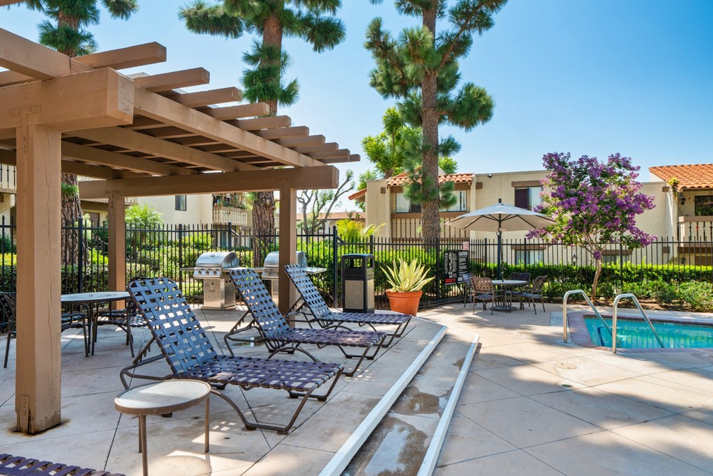 a patio with lounge chairs and a swimming pool