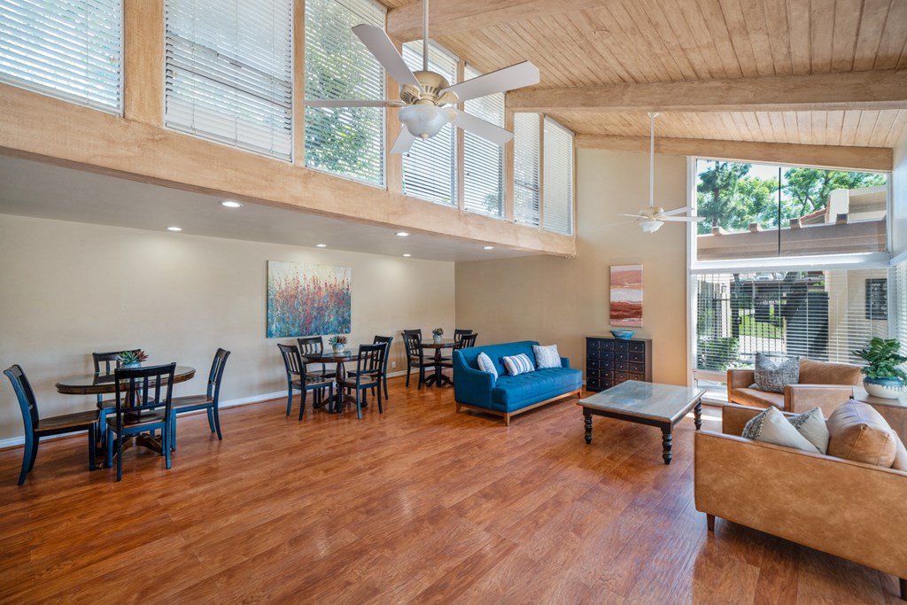 a spacious living room with a ceiling fan and a dining room table